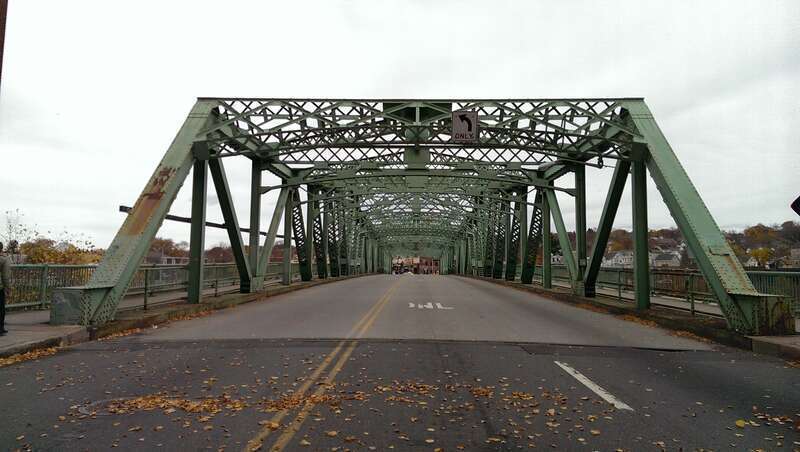 The John E. Cox Memorial Bridge (also known as the Central Bridge), in Lowell, Massachusetts, carries Bridge Street over the Merrimack River.  It was built in 1937.  At the time of the photo, it was temporarily closed to traffic due to  construction