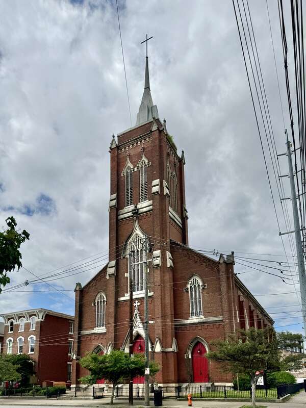 Built in 1866-1867, this Gothic Revival-style building was constructed for St. John’s German Evangelical Church, which later became the St. John United Church of Christ.  The building features a red brick exterior, stone trim, a gable roof, brick