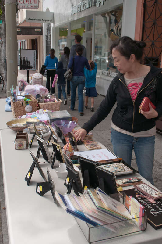 Outside a used bookstore/gift shop, a shopper is looking at some items that are for sale.

Located in the north of San Francisco near the Marina District, Union Street has a collection of quirky shops, some local and independent, some national