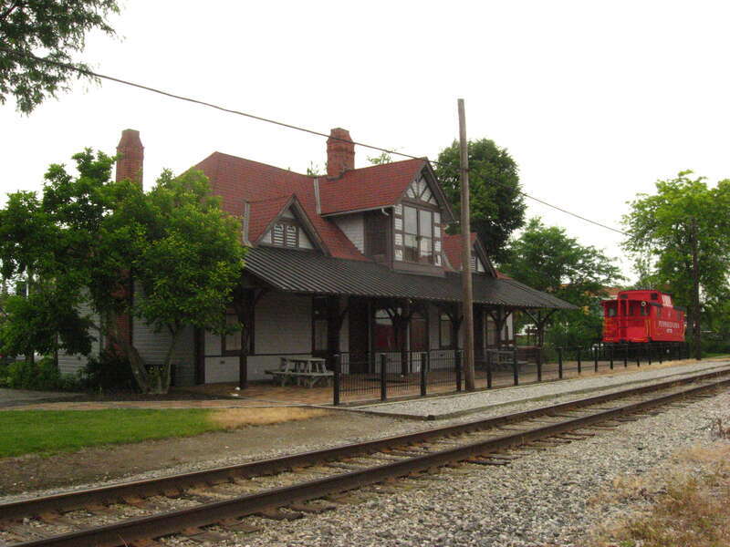 Railroad (northern) side of the Ada Pennsylvania Station and Railroad Park, located as 112 E. Central Avenue in downtown Ada, Ohio, United States.  The caboose is Pennsylvania Railroad #477779.  Built in 1887, it is listed on the National Register of