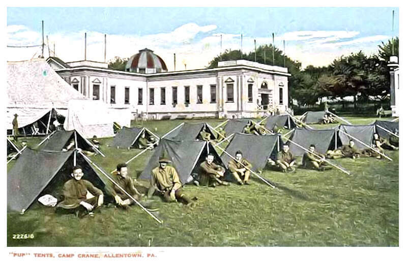This colorized photo postcard, probably taken in the summer of 1917, shows United States Army Ambulance Corps trainees sleeping in pup tents on the grassy area of Camp Crane.  This was the midway area of the Allentown Fairgrounds before World War I