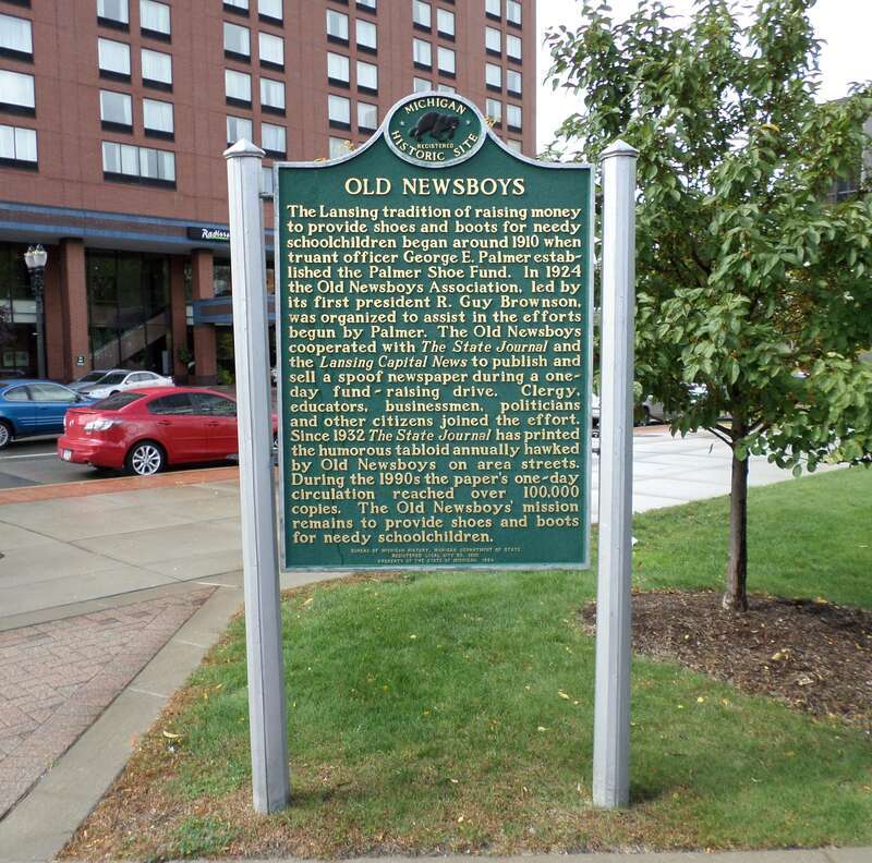 A sign commemorating the Old Newsboys Association, located at E. Michigan Ave and Grand Ave, Lansing, MI.