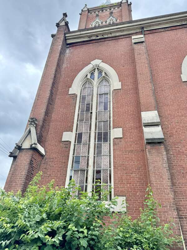 Built in 1866-1867, this Gothic Revival-style building was constructed for St. John’s German Evangelical Church, which later became the St. John United Church of Christ.  The building features a red brick exterior, stone trim, a gable roof, brick