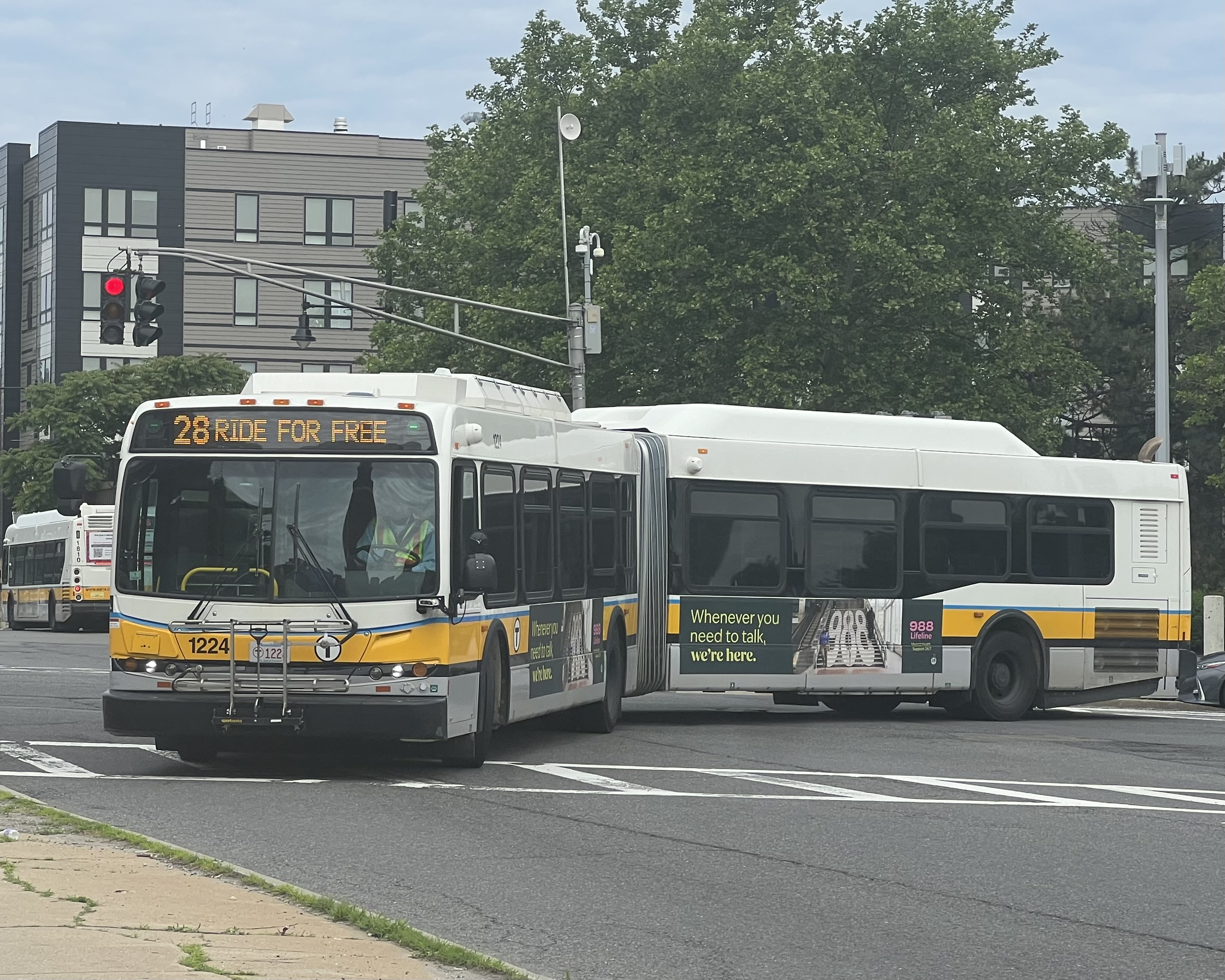 MBTA route 28 bus turning from Tremont Street to Malcolm X Boulevard at Roxbury Crossing in June 2024