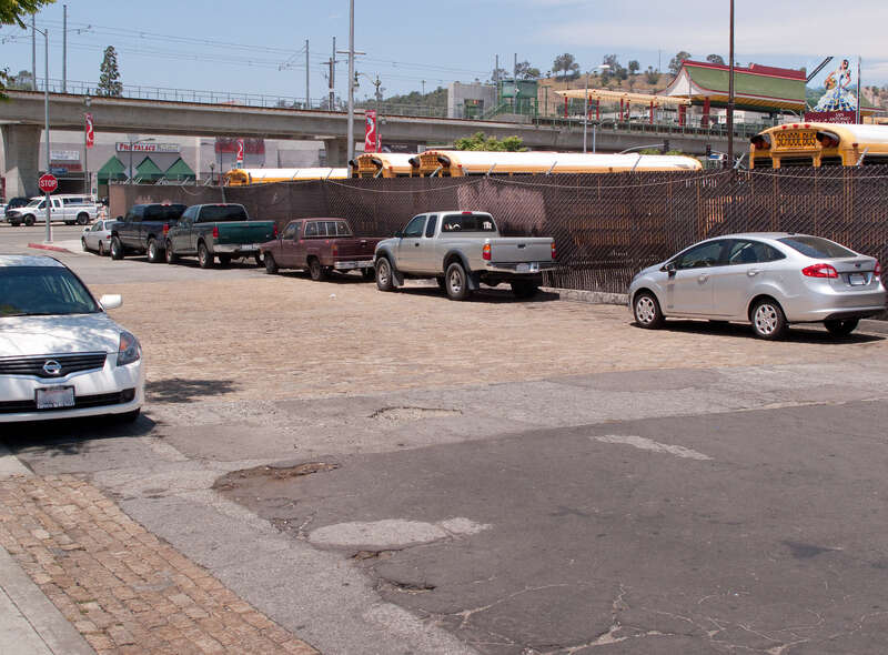 Original granite-block paving, Bruno Street, Los Angeles, California. It has been preserved along both edges of this one-block street, with a patch preserved in the center. The Chinatown station of the Gold Line light rail is in the background.