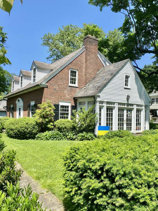 Built in 1940, these Colonial Revival-style houses face towards a shared courtyard and feature red brick exteriors, side gable roofs, six-over-six and eight-over-twelve double-hung windows, three gabled roof dormers on the front, large shed dormers