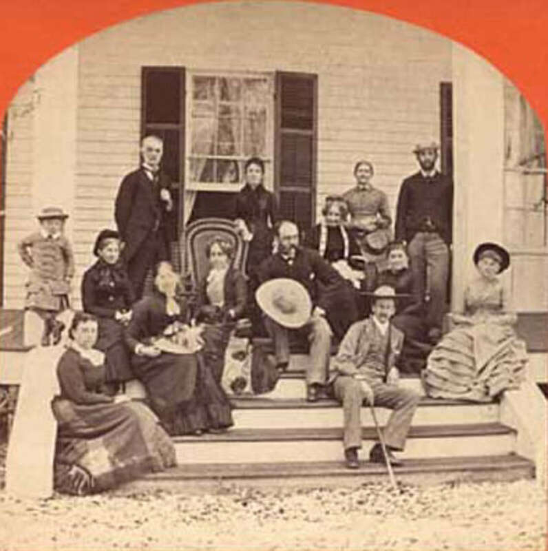 A photo of Charlotte Henry White (seated, center) and possibly her husband Nathaniel P. White (standing left of Charlotte) with a group on the steps of the Bronson-Mulholland House in Palatka, Florida.