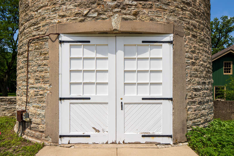 Door, Water tower, Ellwood House, DeKalb, Illinois. &quot;On the west (rear) of the Ellwood House, the circular limestone water tower is about 50 feet (15.2 m) tall and has a diameter of 18 feet (5.5 m). The tower has windows occurring at different