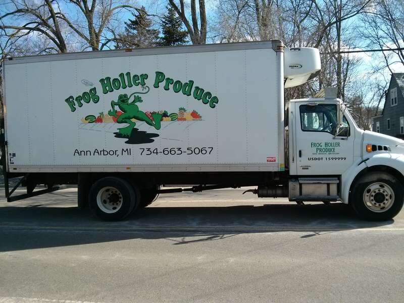 A delivery truck for Frog Holler Produce showing a frog dancing in front of a set of vegetables and fruits. Ann Arbor, Michigan.