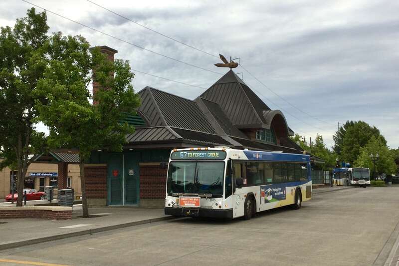 The north side of TriMet's Hillsboro Transit Center, with a bus on line 57 bound for Forest Grove and another, in the background, laying over on line 48-Cornell. On the opposite side of the building is the Hillsboro Central MAX (light rail) station,