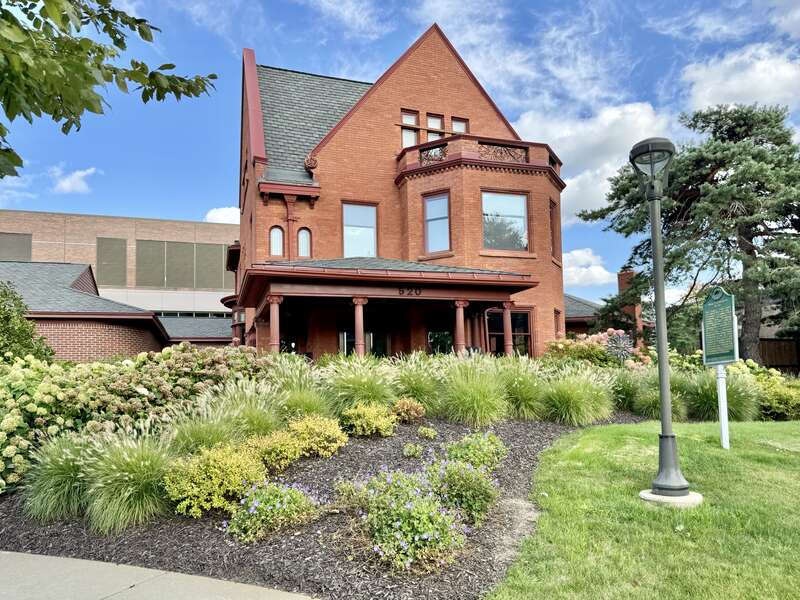 Built in 1893, this Tudor Revival-style house was designed by J. Arthur Bailey for John T. Hermann, a tailor, and remained in the Herrman family until 1966, when it was acquired by Lansing Community College.  The house is clad in red brick with a