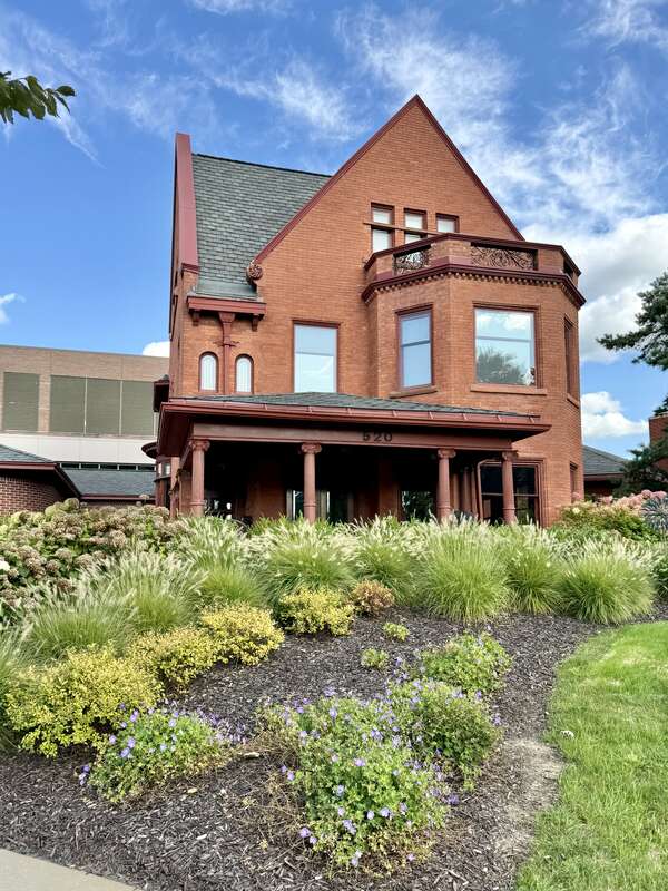 Built in 1893, this Tudor Revival-style house was designed by J. Arthur Bailey for John T. Hermann, a tailor, and remained in the Herrman family until 1966, when it was acquired by Lansing Community College.  The house is clad in red brick with a