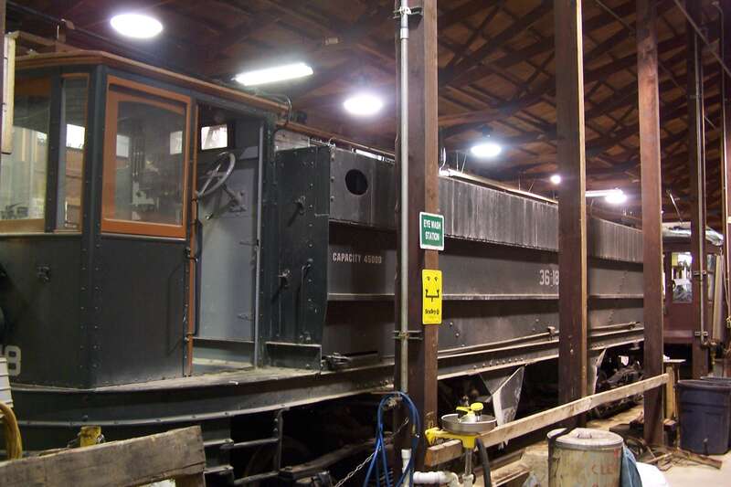 A work car under repair in the shop at the PA Trolley Museum in Washington, PA.  This car will assist in reballasting the &quot;right of way&quot; at the museum.
