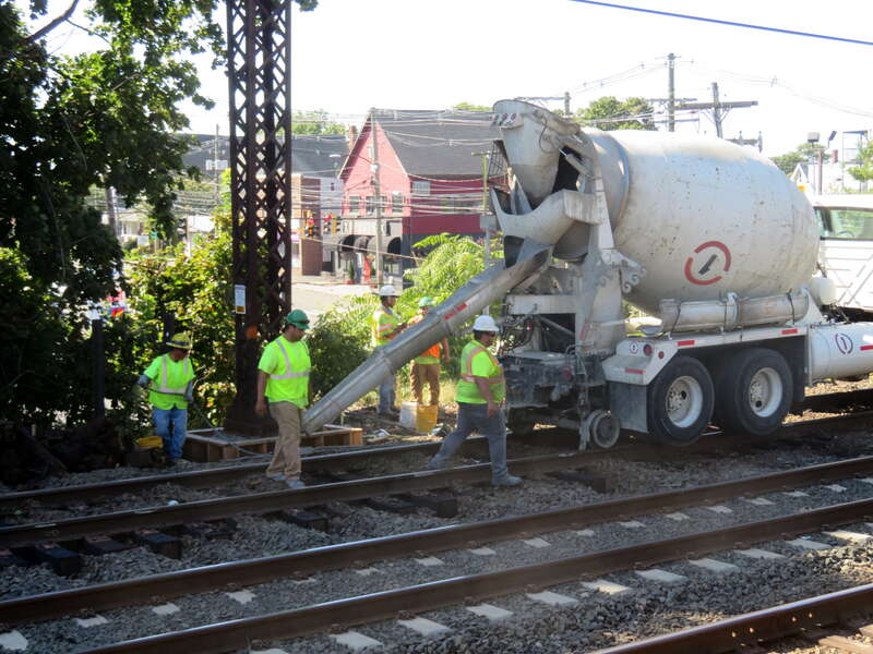 A crew pours concrete at the base of a catenary tower at East Norwalk station in September 2018