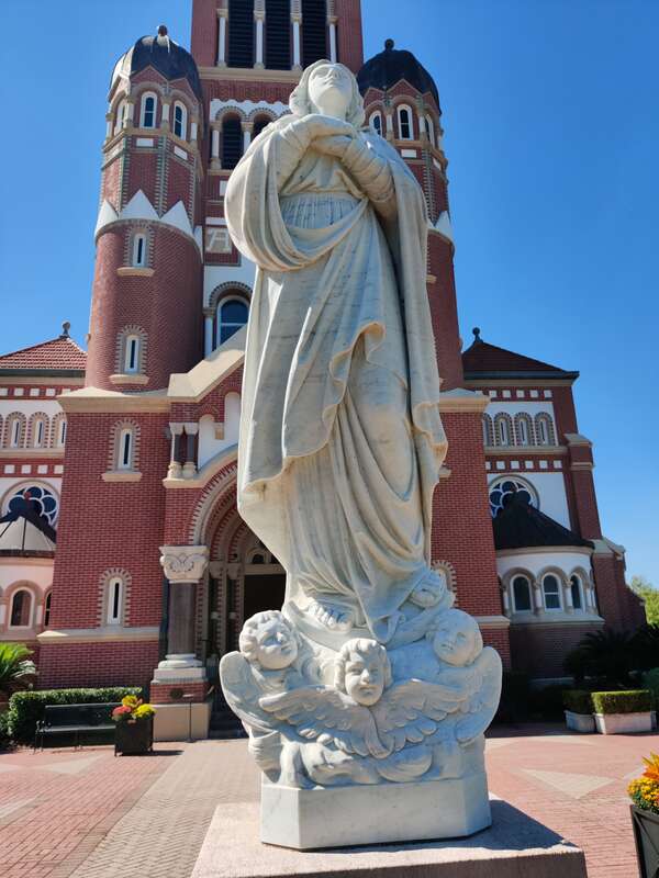 This is a photograph of a statue at the Cathedral of Saint John the Evangelist in Lafayette, Louisiana, United States; it was taken on 16 October 2021 during the Boudin Festival in the afternoon.