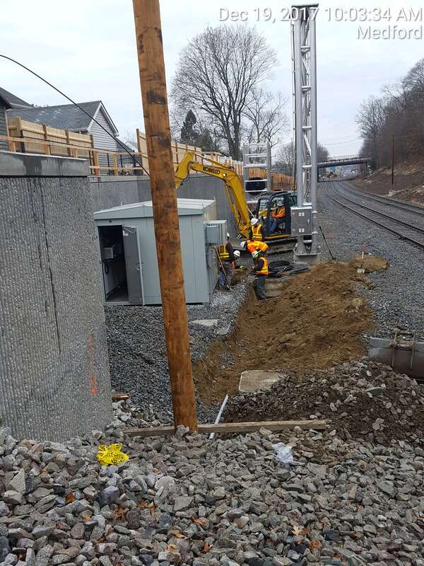 Trenching for Positive Train Control conduit, facing south at North Signal Tower, Medford, College Avenue Bridge in distance..