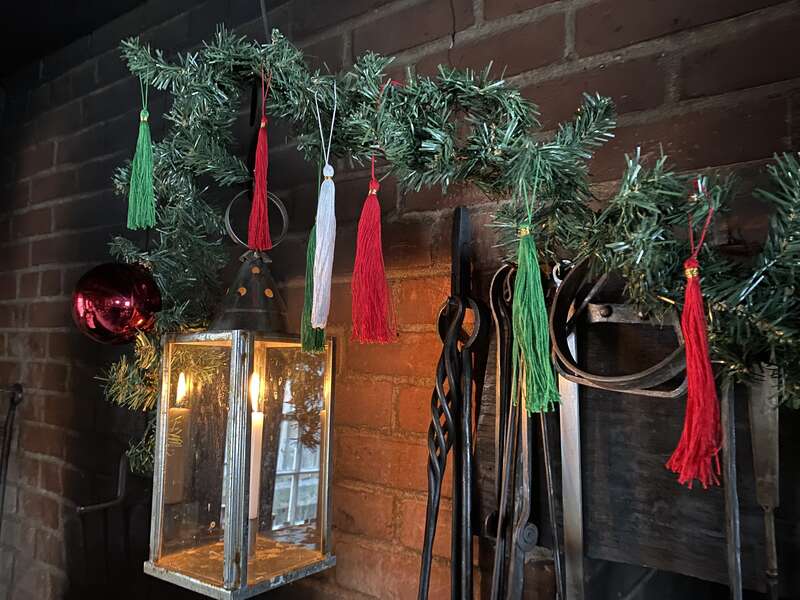 Green, red, and white tassels hanging from a branch in the Fort Vancouver kitchen.
Your finished tassels make a great, colorful decoration!