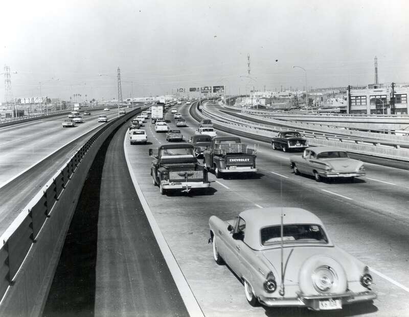 Traffic on the Santa Monica Freeway (I-10) near the intersection with the Santa Ana (I-105) and Golden State Freeways (I-5). Note the use of the corrugated plastic shield on the median barrier rail.