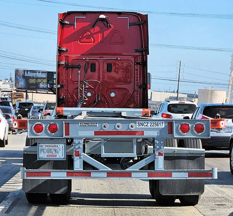 Schneider National shipping container semi-trailer from the rear on I-710 in Bell, California, USA.