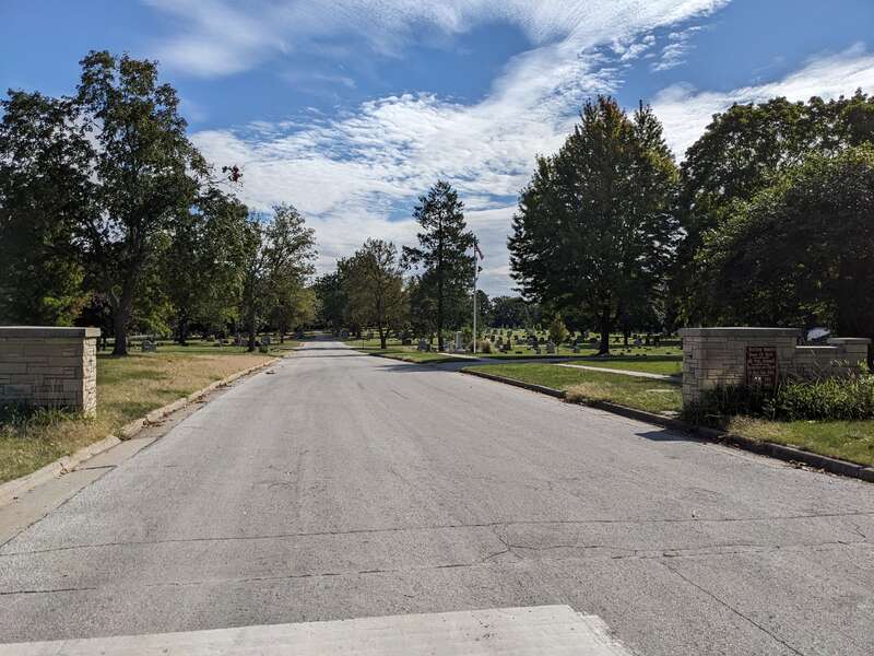 Road, trees and entry wall to cemetery