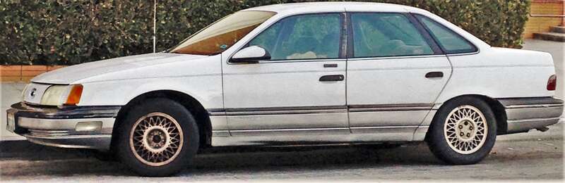 First Gen Ford Taurus parked on a quiet residential street in Alhambra