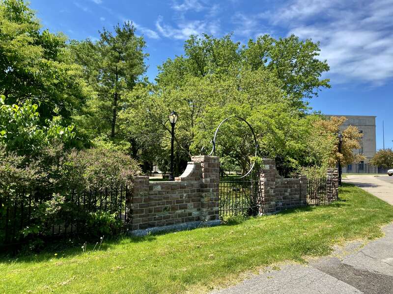 As seen in May 2021: the imposing stone fencing surrounding the &quot;cottage garden&quot; at Martin Luther King, Jr. Park, designed by pioneering African-American architect John Brent. Tucked away inconspicuously behind the Science Museum, facing the parking