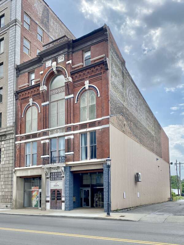 Built in 1883, this Romanesque Revival and Italianate-style building was constructed to serve as a Masonic Temple.  The building features a red brick exterior with roman arched window bays on the third floor, one-over-one double-hung windows, a