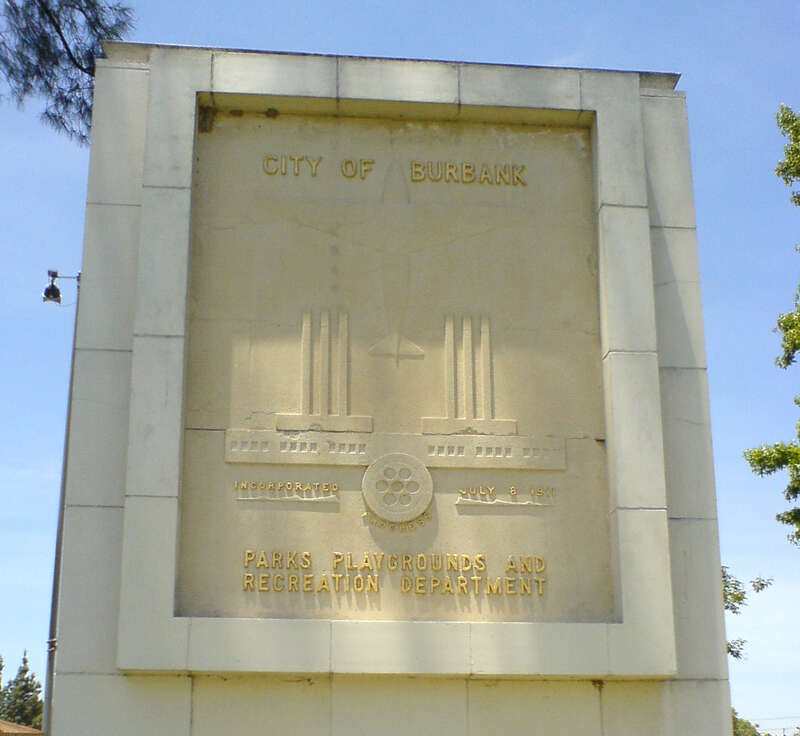 Marker inside of Olive Park.   The design is the former city seal, showing Burbank as a city of industry and aviation, with a nascent film industry represented by the film reel.