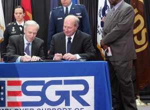 SANDY SPRINGS, Feb. 13, 2013  - Major Gen. Jim Butterworth (center standing), Georgia's Adjutant General, along with UPS employees who serve in the Guard and Reserve, watch while Scott Davis (seated left), UPS chairman and CEO, and James Rebholz,