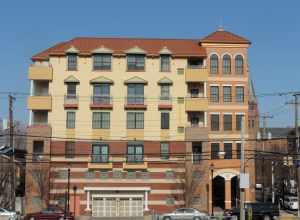 Looking west across Avenue E from 22nd Street station at apartment house on a sunny morning.