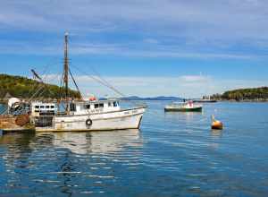 500px provided description: The Wind Spirit lobster boat in the ocean near Bar Harbor as seen from the tour boat from Bar Harbor Whale Watch Lighthouse Tour in October. [#sky ,#landscape ,#october ,#sea ,#water ,#reflection ,#travel ,#island ,#blue