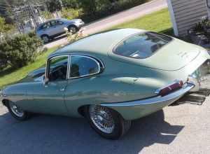 Jaguar E-Type coupe at ExxonMobil gas station on VT Rte 15 in Morrisville, Vermont (rearview).