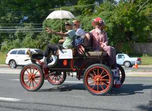 An old car with the grand Marshal at the start of the Kensington, Maryland 2014 Labor Day Parade.