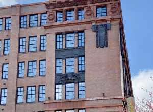 Built in 1906, this Beaux Arts-style building was designed by Eames and Young for the Ely and Walker Dry Goods Company.  The building features a red brick exterior with orange and black terra cotta trim, one-over-one double-hung windows, rusticated
