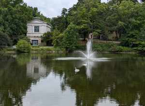 A view of the north wall of Wade Memorial Chapel, across the lank, with a fountain and swans in the background